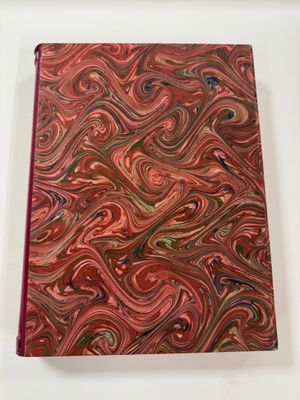 a close up of a red notebook with a swirl design on it