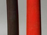 deux vases rouges et noirs posés l'un à côté de l'autre sur une table