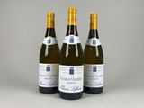 trois bouteilles de vin blanc posées les unes à côté des autres sur une table