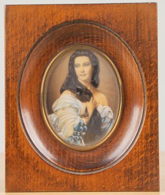 une vieille photo d'une femme en robe bleue, dans un cadre en bois
