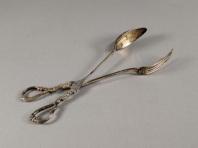 une paire de ciseaux et une paire de cuillères posées sur une table