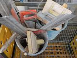 un seau rempli d'outils posé sur une étagère