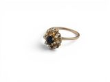 a close up of a gold ring with a blue stone
