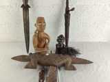 a statue of a man sitting on top of an alligator next to a knife
