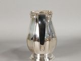an image of a silver vase sitting on top of a white table