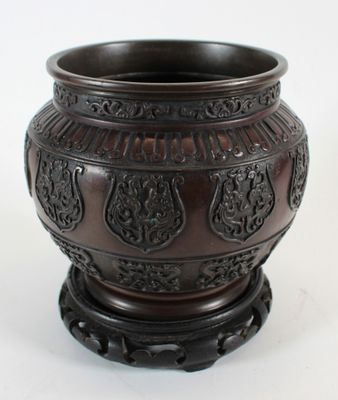 un vase brun posé sur une surface blanche