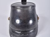a small metal container with a lid on a white surface