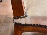 a close up of a wooden chair with a chain on it