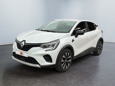 Une voiture blanche est garée dans une pièce au sol noir.