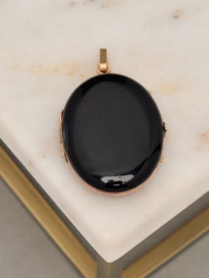 an image of a black pendant sitting on top of a marble table