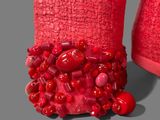a close up of a pair of red shoes with red beads on them