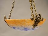a small bowl hanging from a chain on a wall
