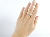a woman ' s hand with a diamond ring on it