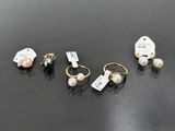 trois paires de boucles d'oreilles et une étiquette sur un fond noir