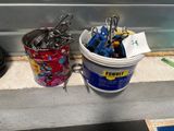 a bucket of scissors next to a bucket of pencils on a counter