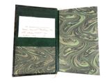 an old book with a green cover and writing on it