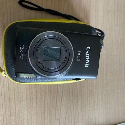 un appareil photo posé sur une table, avec une sangle autour