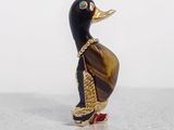 a black and gold duck figurine sitting on a white surface