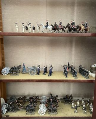 de nombreuses figurines exposées sur une étagère dans une vitrine