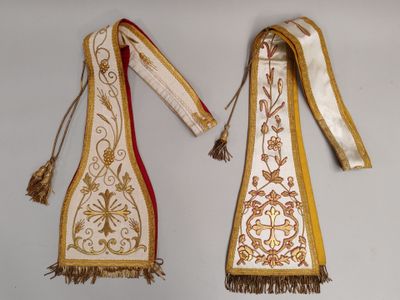 deux morceaux de tissu ornés de pompons, suspendus à un mur