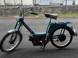a small blue bike parked on the side of the road