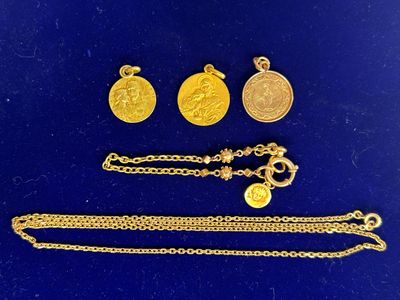un gros plan sur un ensemble de bijoux en or posés sur une surface bleue