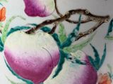a white vase with a painting of peachs on it