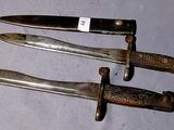 three knives are sitting on a table with a tag on them
