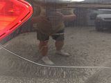 a reflection of a man in the rear window of a car