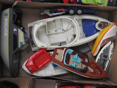 une boîte en carton remplie de petits bateaux et d'autres jouets
