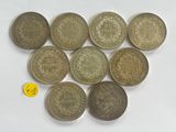 six different types of coins are arranged on a white surface