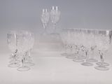 Plusieurs verres à vin transparents sont alignés sur une surface blanche