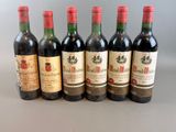 six bottles of wine are lined up in a row on a table