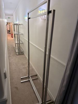 un long couloir avec un miroir et un porte-vêtements à l'intérieur