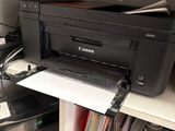 a printer sitting on top of a desk next to a monitor