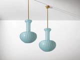 deux vases en verre bleu suspendus au plafond dans une pièce blanche
