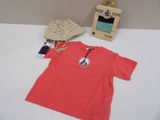 un t-shirt rouge et une casquette posés sur une table