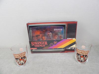 deux verres à shot posés à côté d'un téléviseur