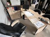 a desk with a chair and a monitor in a room
