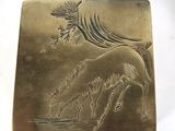a metal box with a horse on it on a white surface