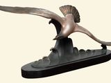 statue représentant un oiseau volant au-dessus d'un bateau sur fond blanc