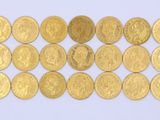 a close up of a pile of gold coins on a white surface