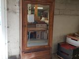 une grande armoire en bois surmontée d'un miroir