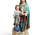 the statue of the virgin and child is standing on a rock