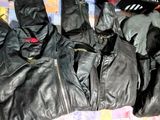 plusieurs paires de gants en cuir noir posées sur un lit