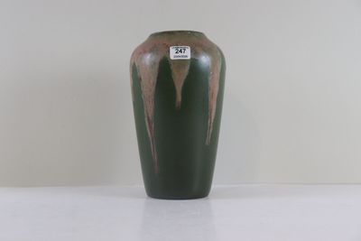 un vase vert posé sur une surface blanche