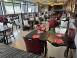 many tables and chairs in this restaurant with red and white napkins