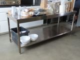une table en acier inoxydable sur laquelle sont posés des bols et des assiettes