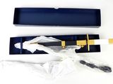 a knife in a blue box with a gold handle
