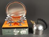 une théière en argent et une théière en argent posées sur une table
